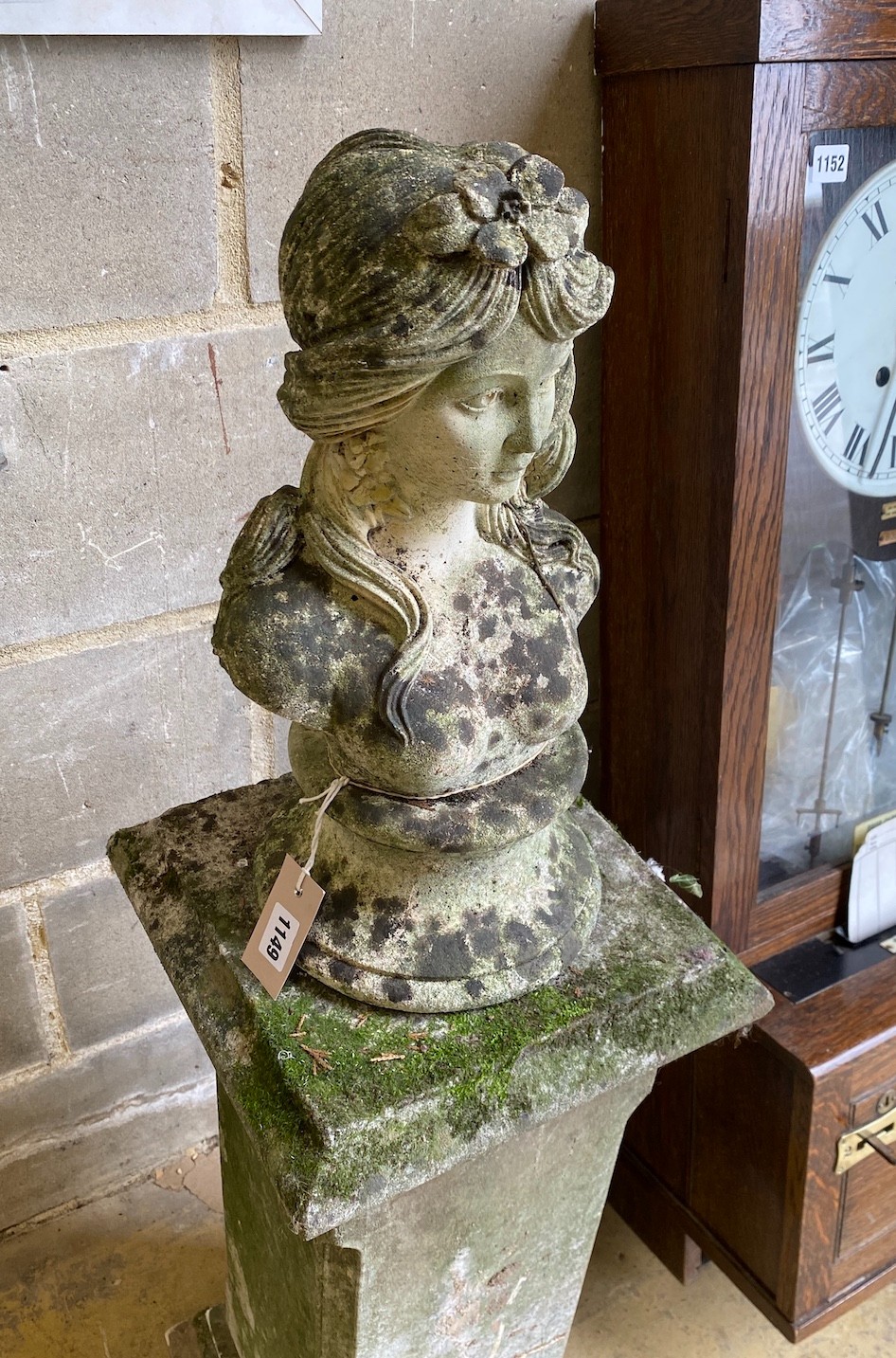A reconstituted stone bust of a girl on a square plinth, height 112cm